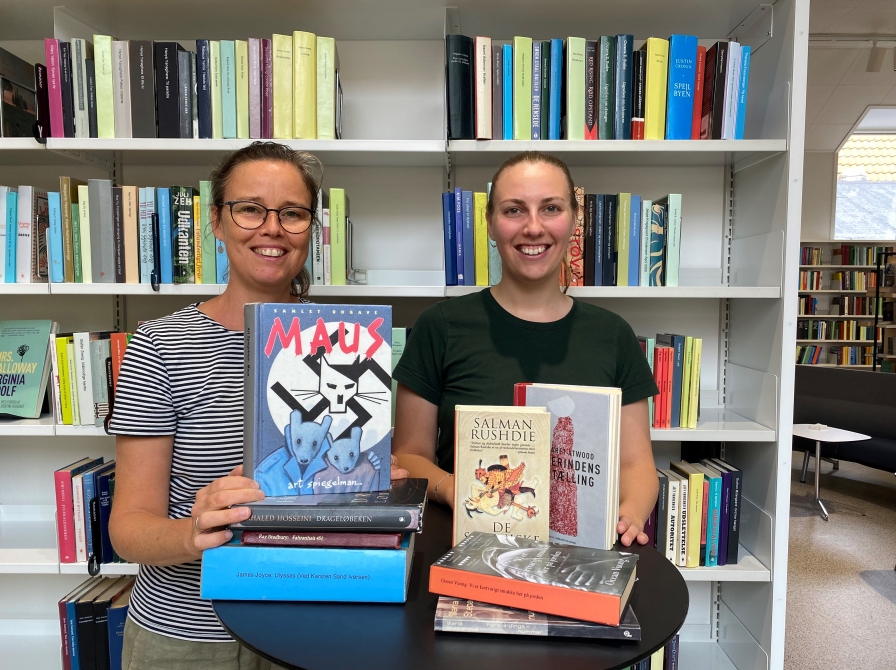 Foto af to kvinder, der står bag et bord med bøger